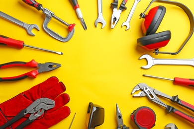 Photo of Flat lay composition with construction tools on color background, space for text