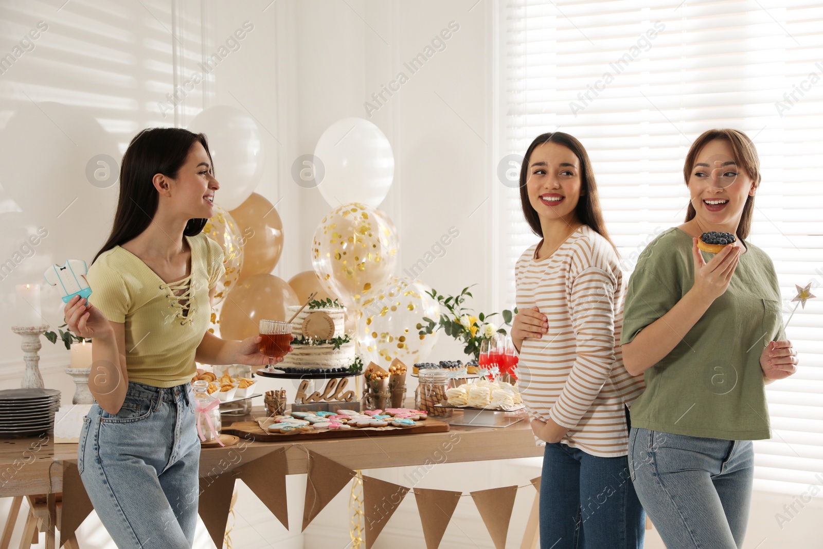 Photo of Happy pregnant woman spending time with friends at baby shower party