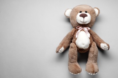 Photo of Cute teddy bear on grey background, top view. Space for text