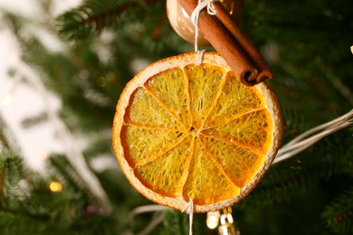 Handmade decor of dry orange slice and cinnamon stick on Christmas tree, closeup