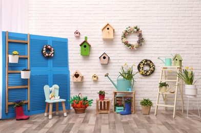 Photo of Elegant Easter photo zone with floral decor and birdhouses indoors