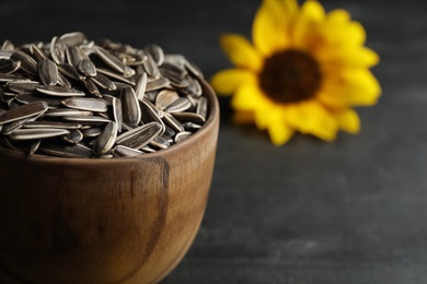 Raw sunflower seeds on black table, closeup. Space for text