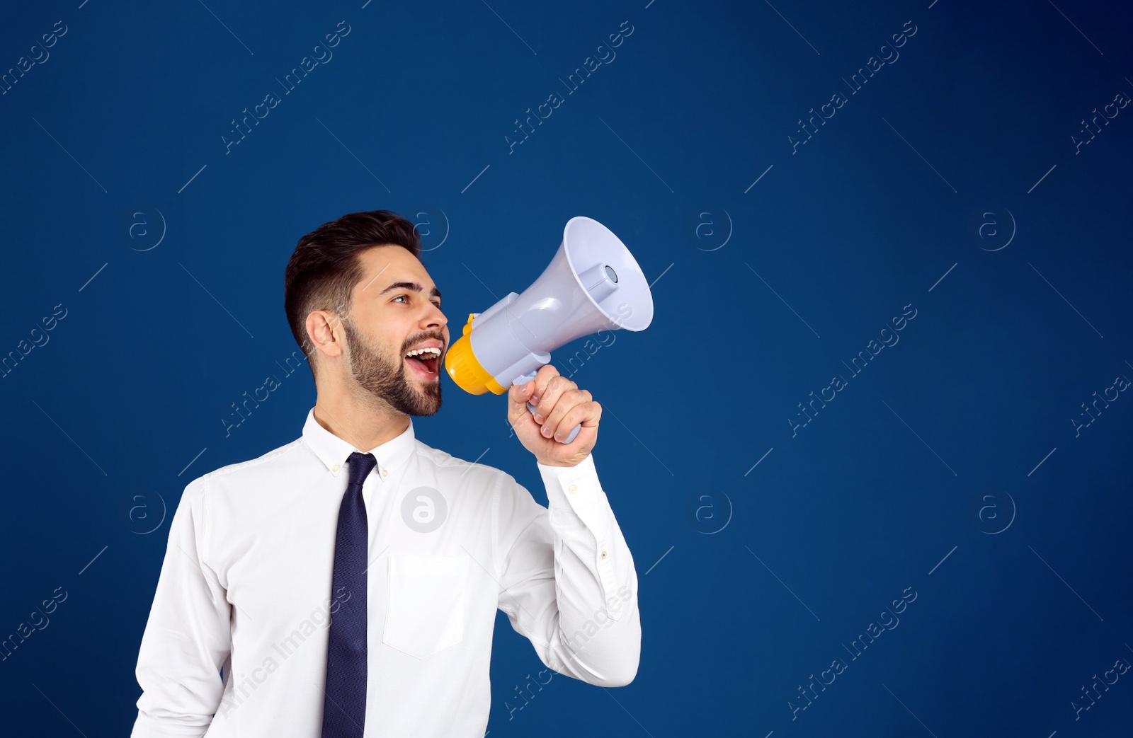 Photo of Young man with megaphone on blue background