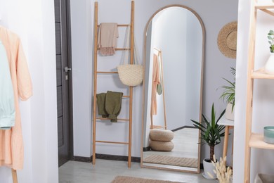 Photo of Hallway interior with wooden ladder and floor mirror