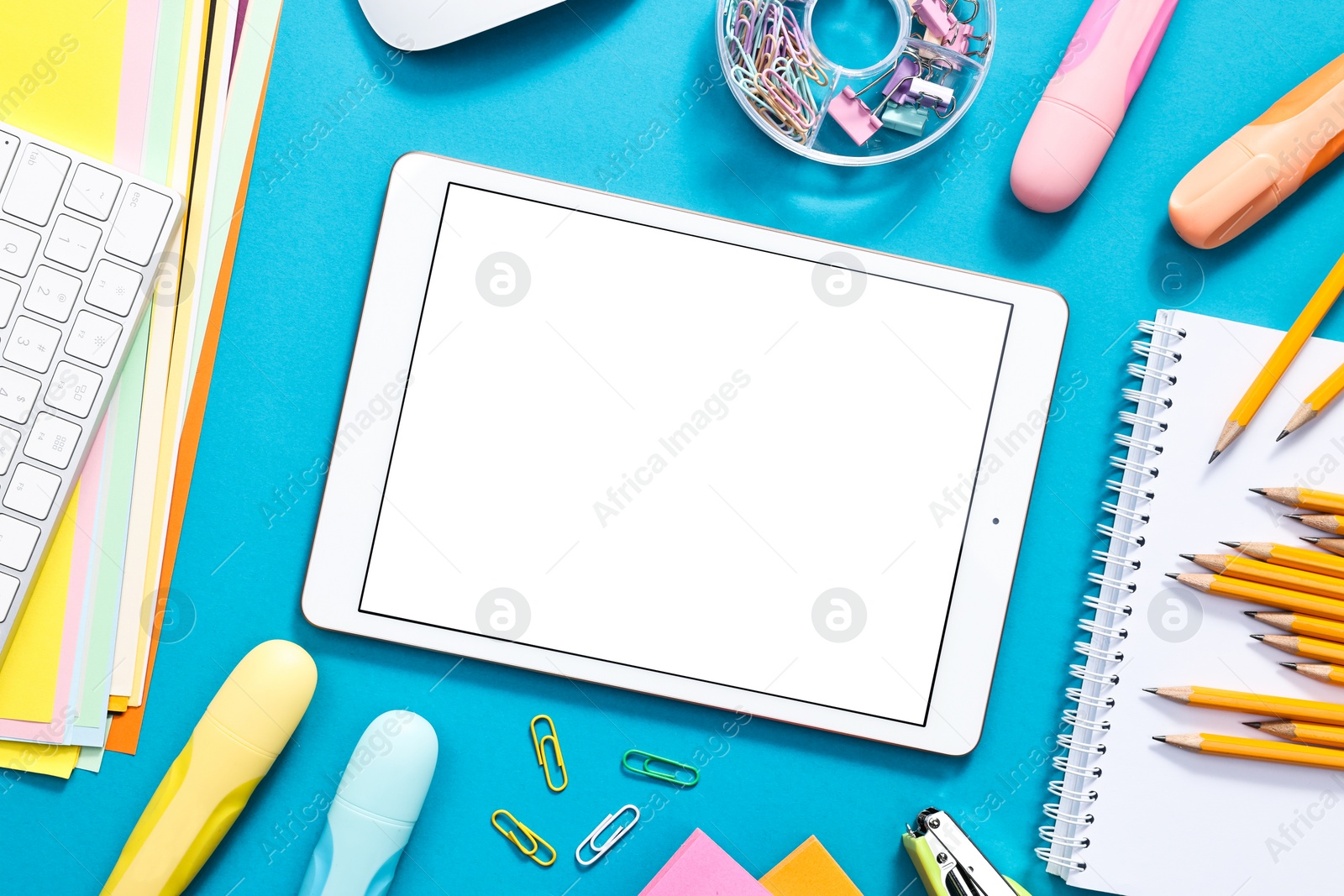 Photo of Modern tablet and stationery on light blue background, flat lay. Space for text