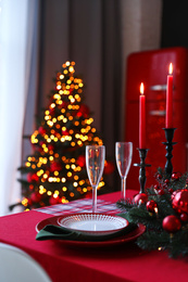 Photo of Table served for festive dinner and Christmas tree in stylish kitchen interior