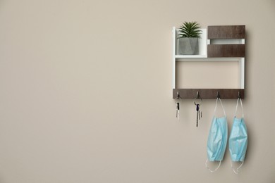 Photo of Wooden key holder on beige wall. Space for text