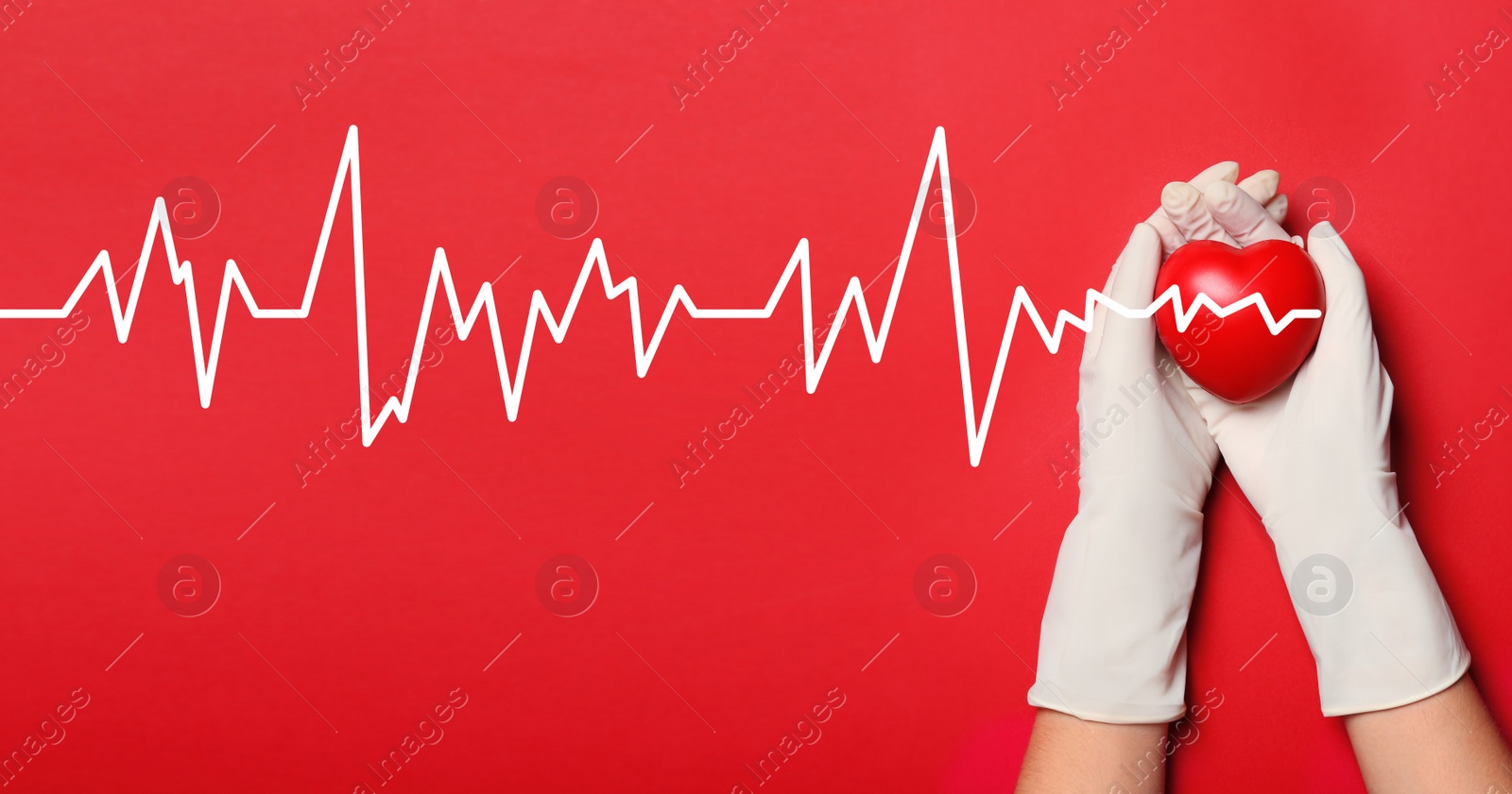 Image of Doctor in medical gloves holding heart on red background, top view