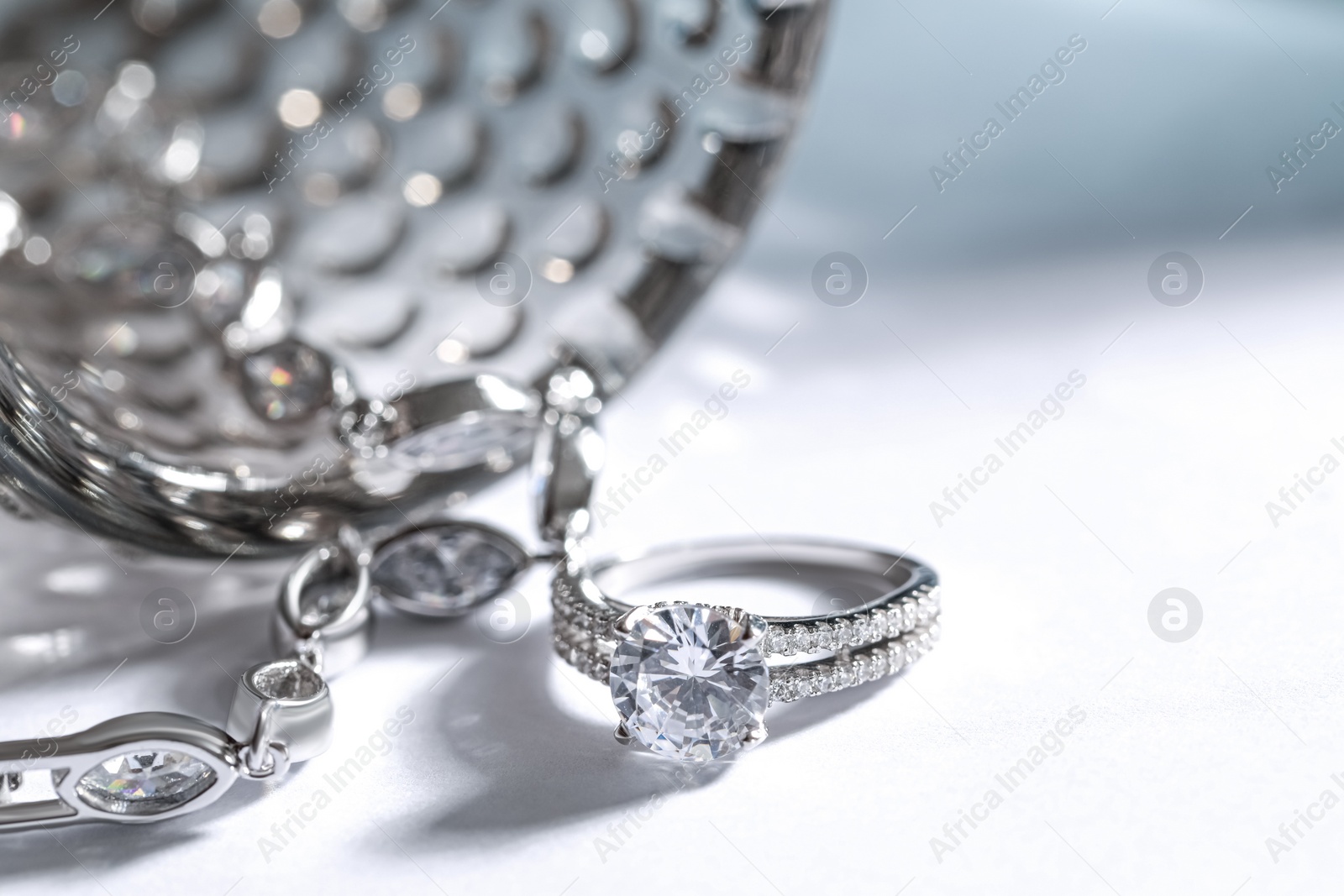 Photo of Elegant jewelry. Stylish presentation of luxury bracelet and ring on white background, closeup. Space for text
