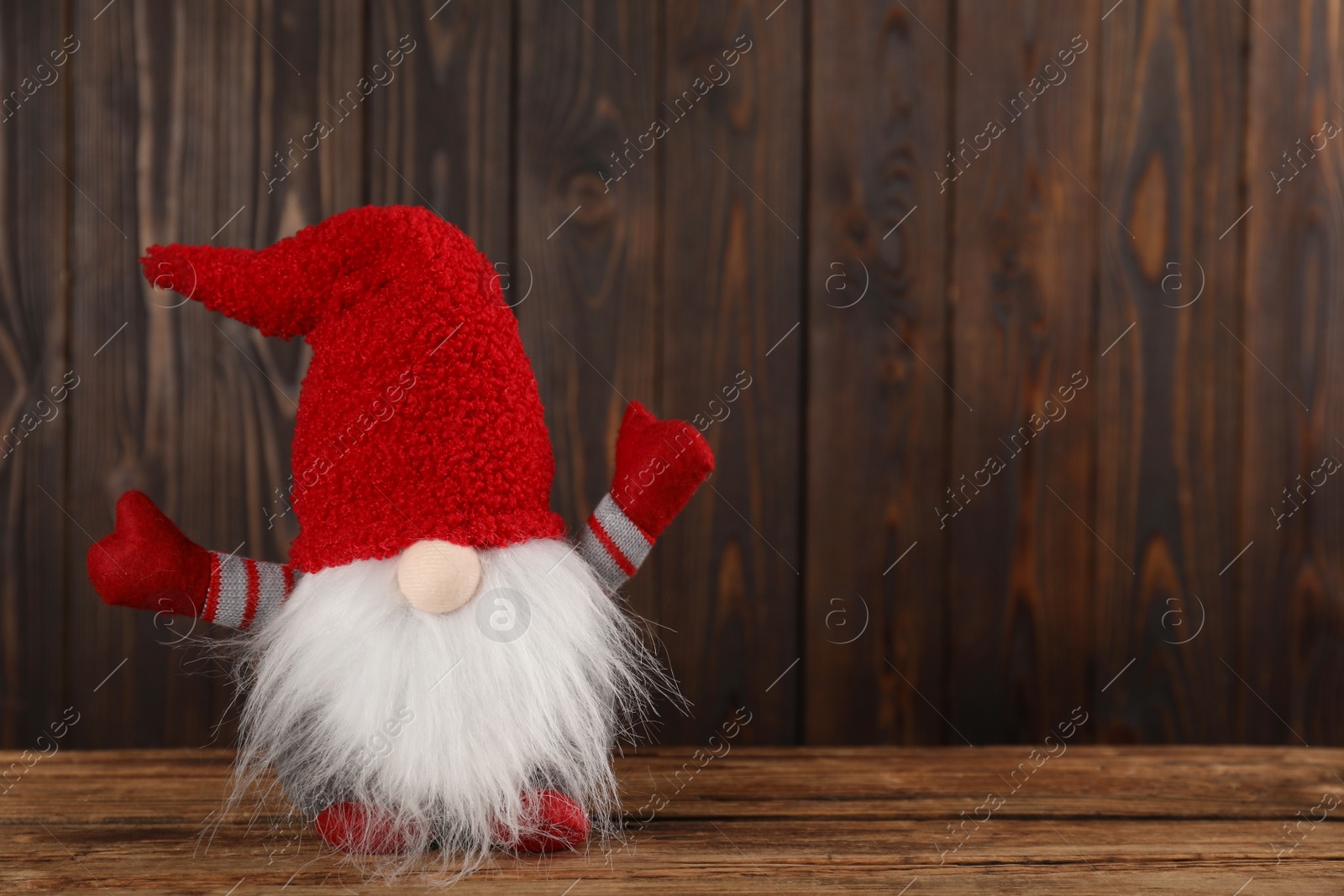 Photo of Cute Christmas gnome on wooden table. Space for text