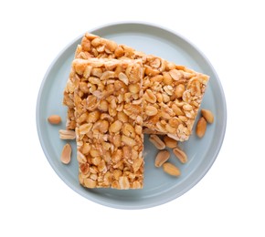 Photo of Plate with tasty kozinaki bars and peanuts isolated on white, top view