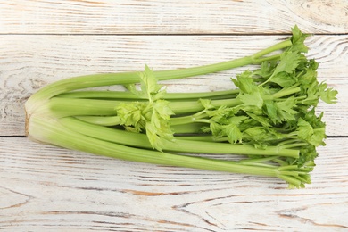 Fresh ripe green celery on white wooden table, top view