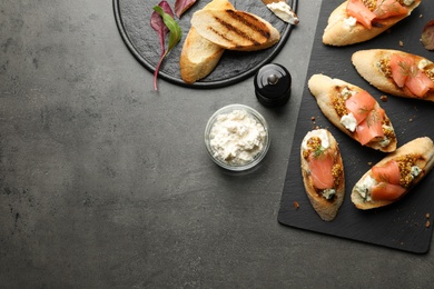 Photo of Flat lay composition with tasty bruschettas on grey table. Space for text