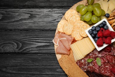 Photo of Snack set with delicious Parmesan cheese on black wooden table, top view. Space for text
