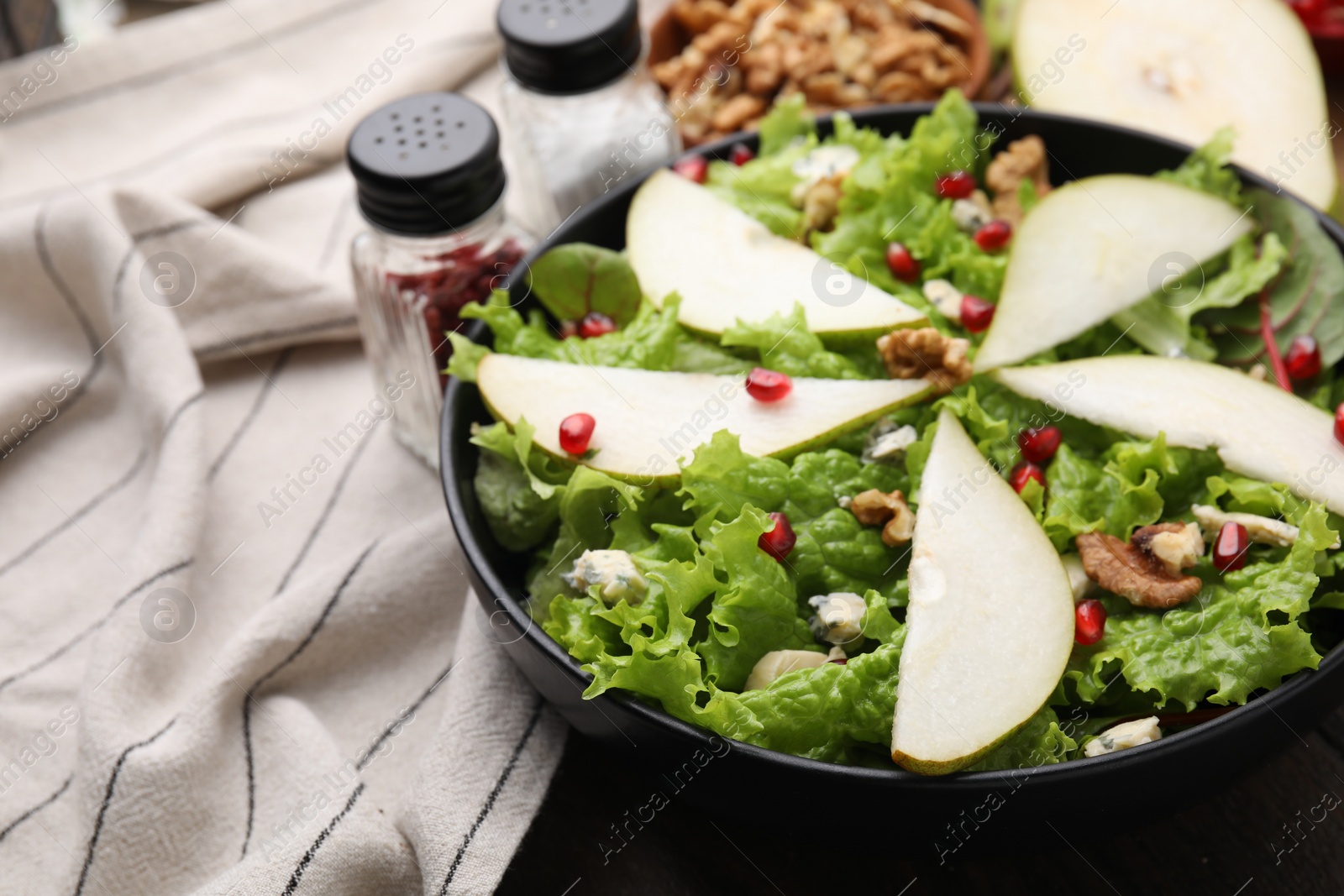 Photo of Delicious pear salad in bowl on table, closeup