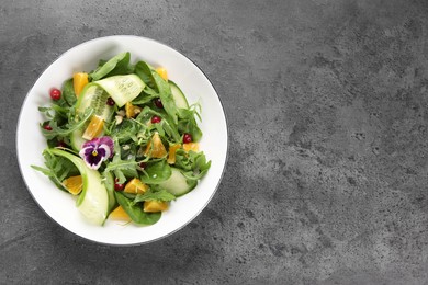 Delicious salad with cucumber and orange slices on gray table, top view. Space for text