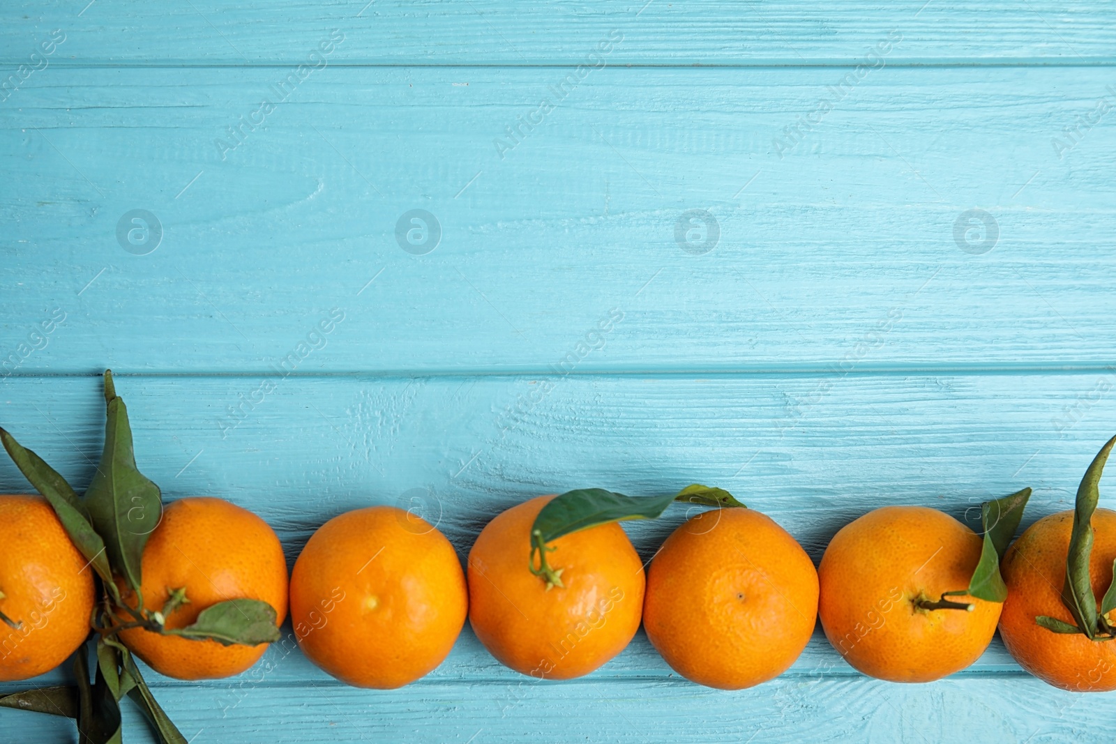 Photo of Fresh ripe tangerines and space for text on wooden background, top view