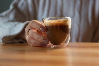 Woman with aromatic coffee at table in cafe, closeup