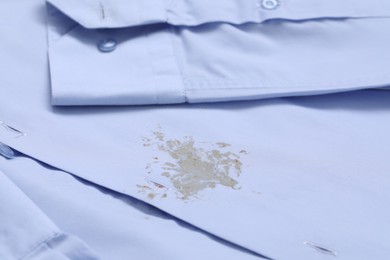 Closeup view of light blue shirt with stain