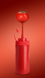 Image of Ketchup made of organic tomatoes. Juice pouring from vegetable into plastic squeeze bottle against red background