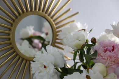 Photo of Bouquet of beautiful peony flowers near mirror, closeup