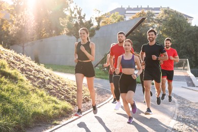 Group of people running outdoors on sunny day