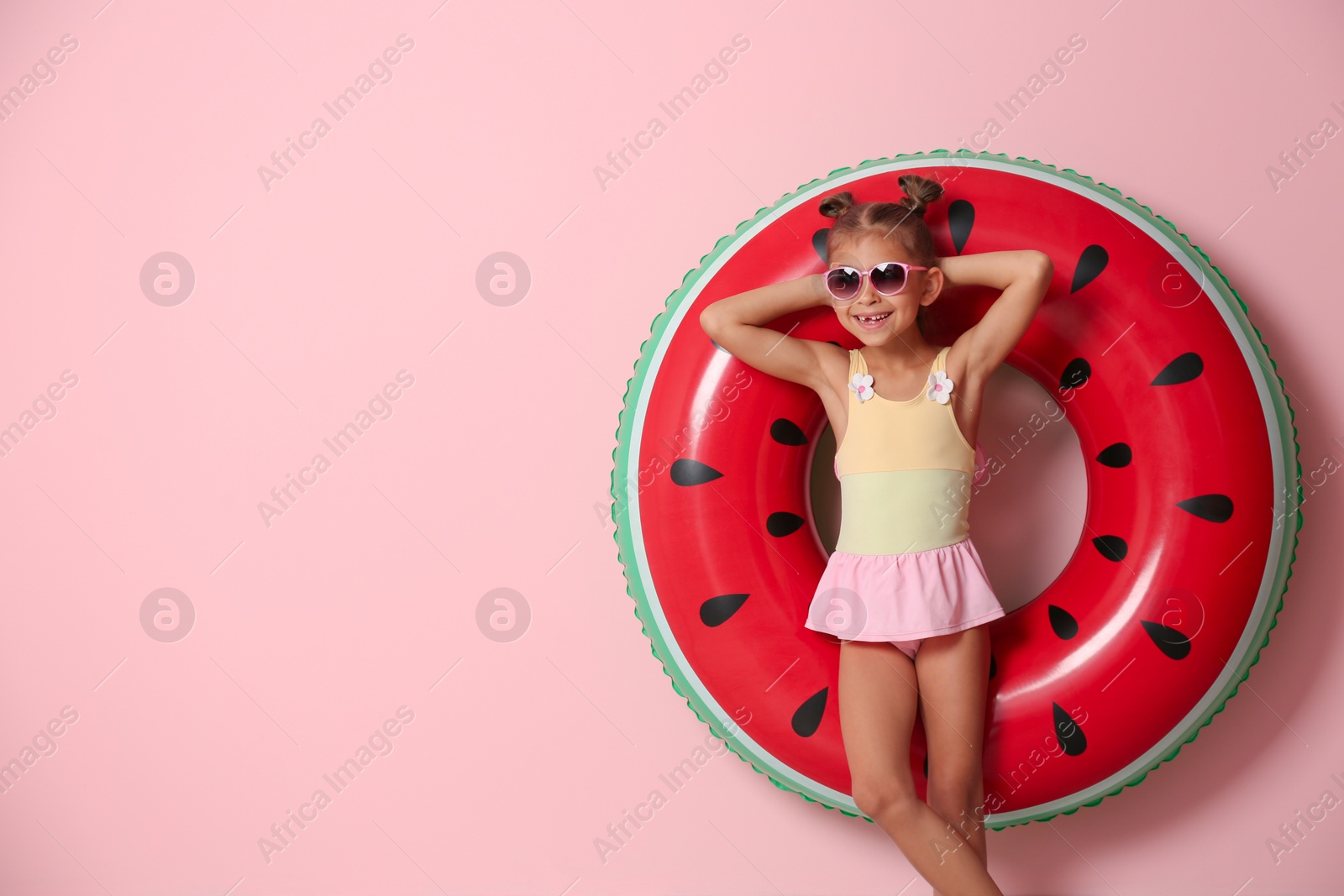 Photo of Cute little girl with inflatable ring on color background