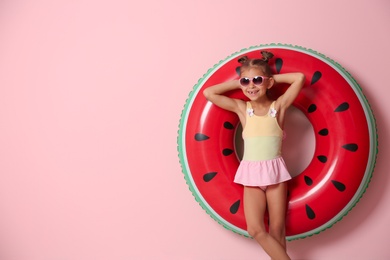 Photo of Cute little girl with inflatable ring on color background