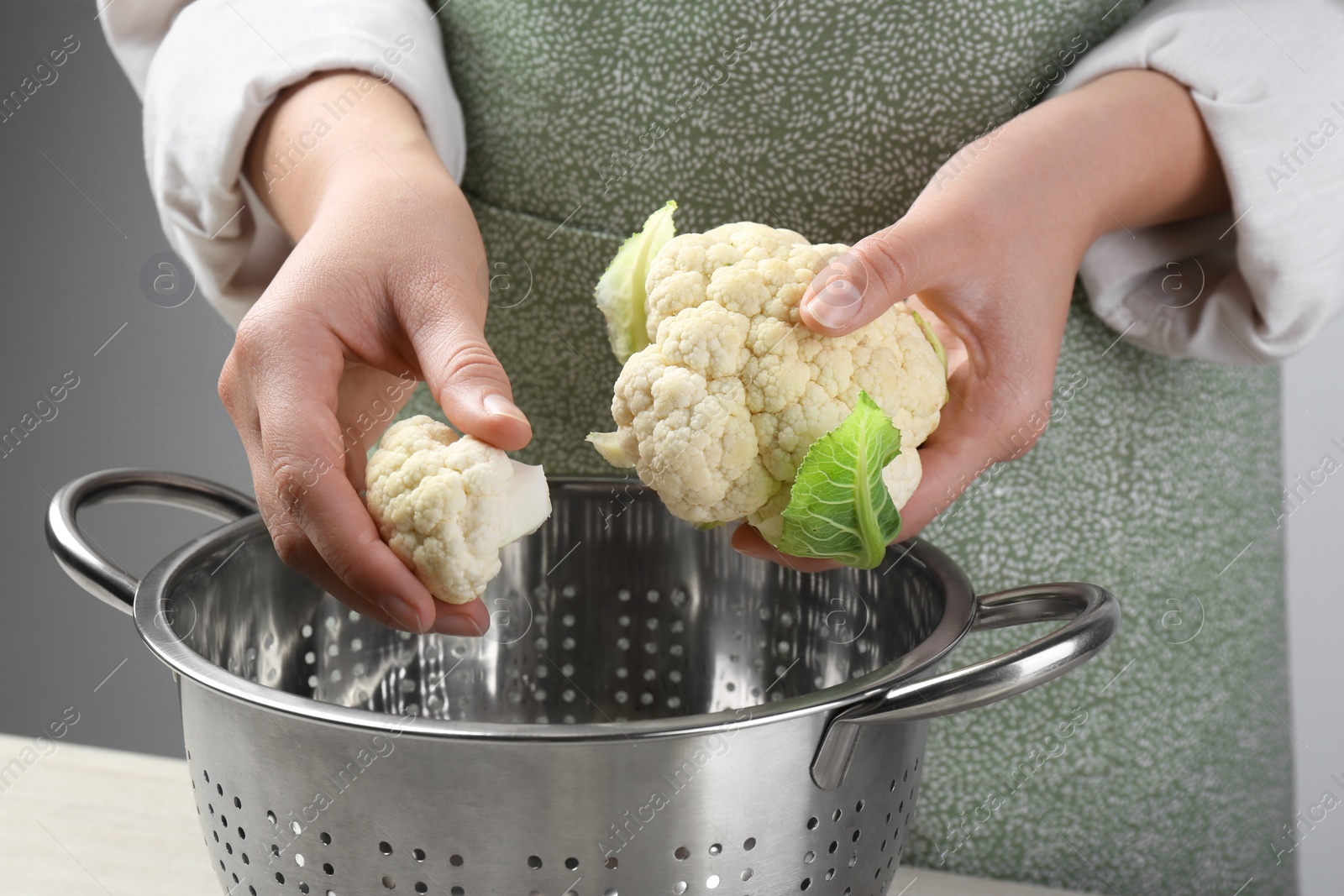 Photo of Woman with fresh cauliflower cabbage near colander, closeup