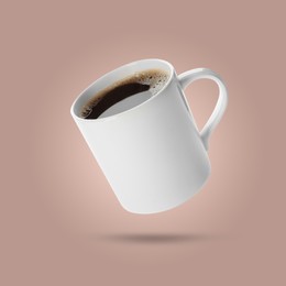Image of White cup of coffee levitating on beige background