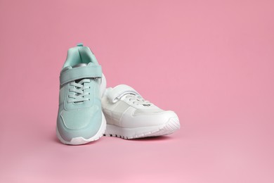 Photo of Two stylish sneakers on pink background. Space for text