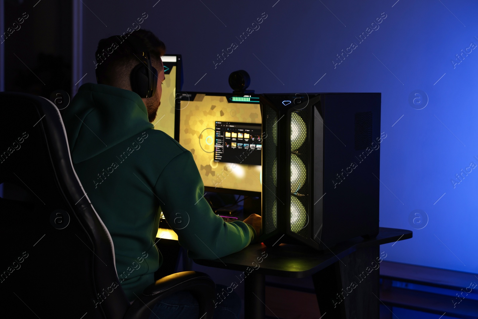 Photo of Man playing video games on computer at table indoors