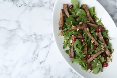 Photo of Delicious salad with beef tongue, arugula and seeds on white marble table, top view. Space for text