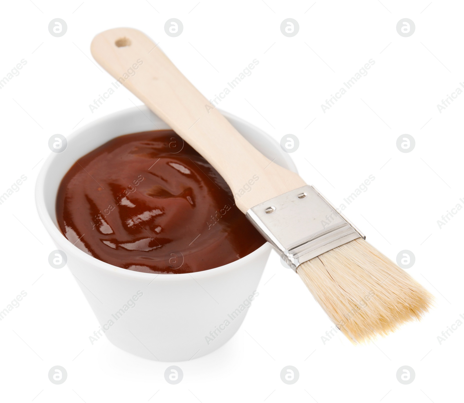 Photo of Marinade in bowl and basting brush isolated on white