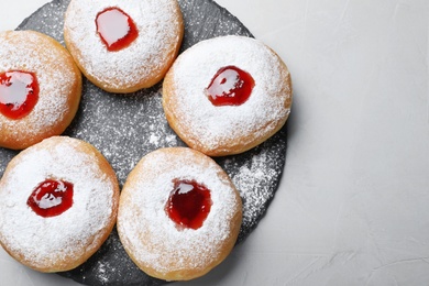 Photo of Hanukkah food doughnuts with jelly and sugar powder served on grey table, top view