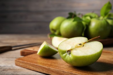 Photo of Cut fresh green apple on wooden table, closeup