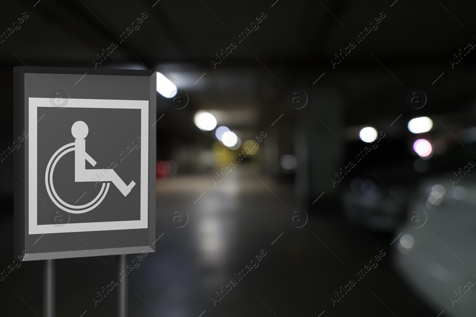 Image of Sign with wheelchair symbol in car parking garage, space for text 