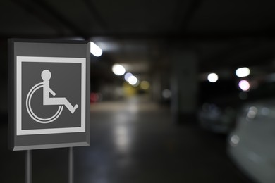 Image of Sign with wheelchair symbol in car parking garage, space for text 