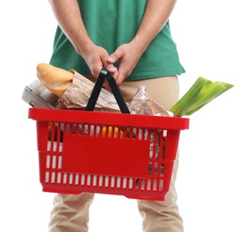 Young man with shopping basket full of products isolated on white, closeup