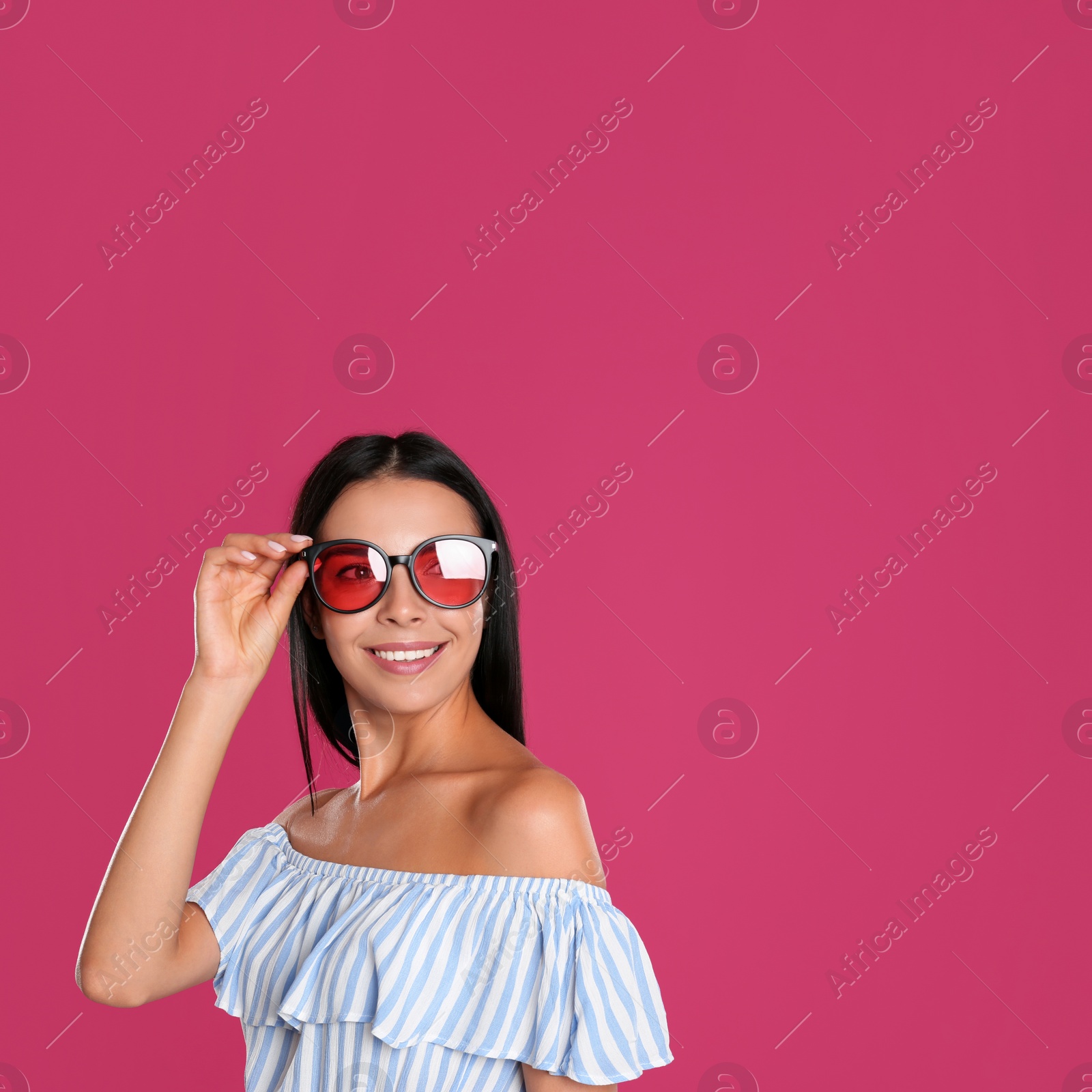 Photo of Beautiful woman wearing sunglasses on pink background. Space for text