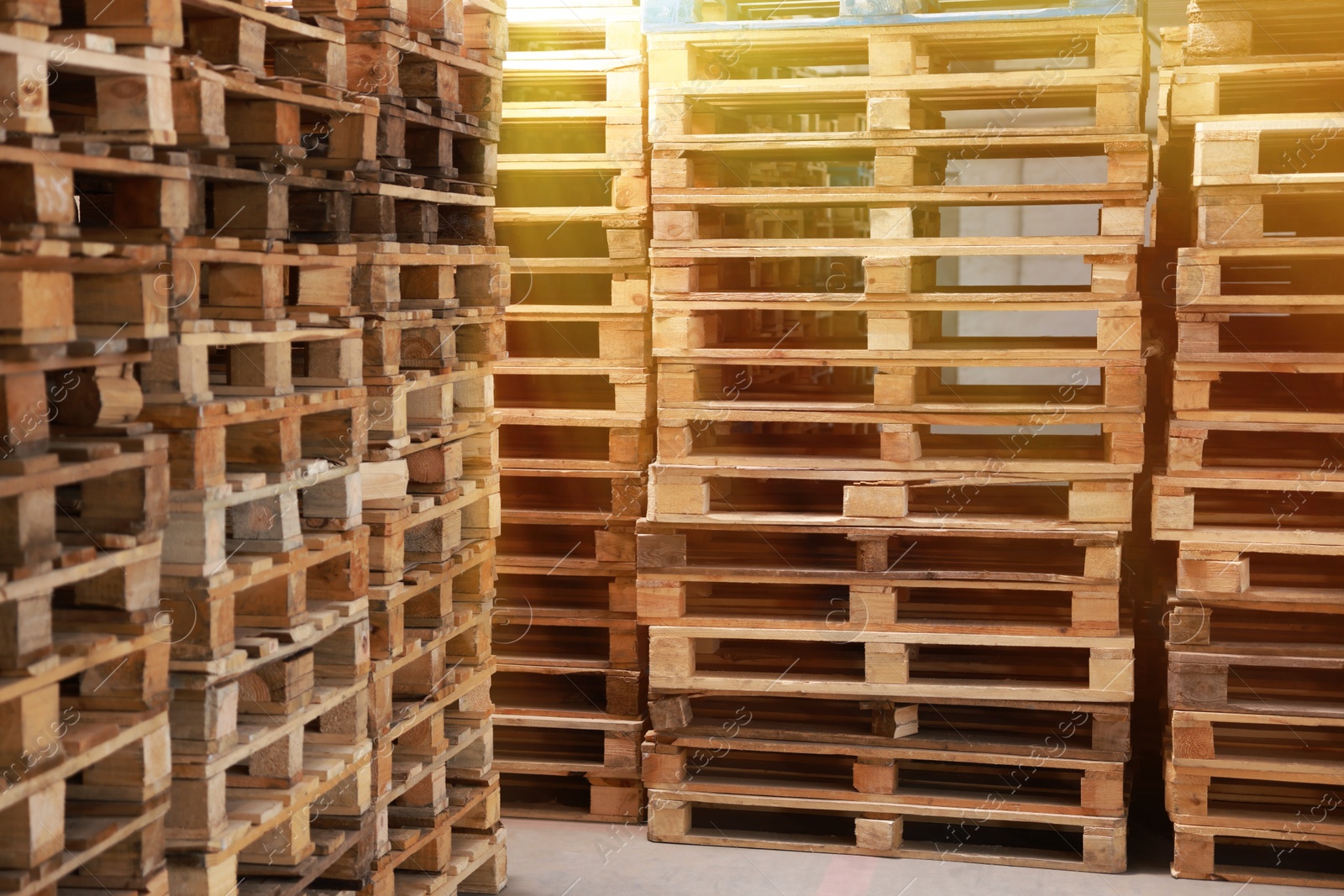 Image of Many empty wooden pallets stacked in warehouse