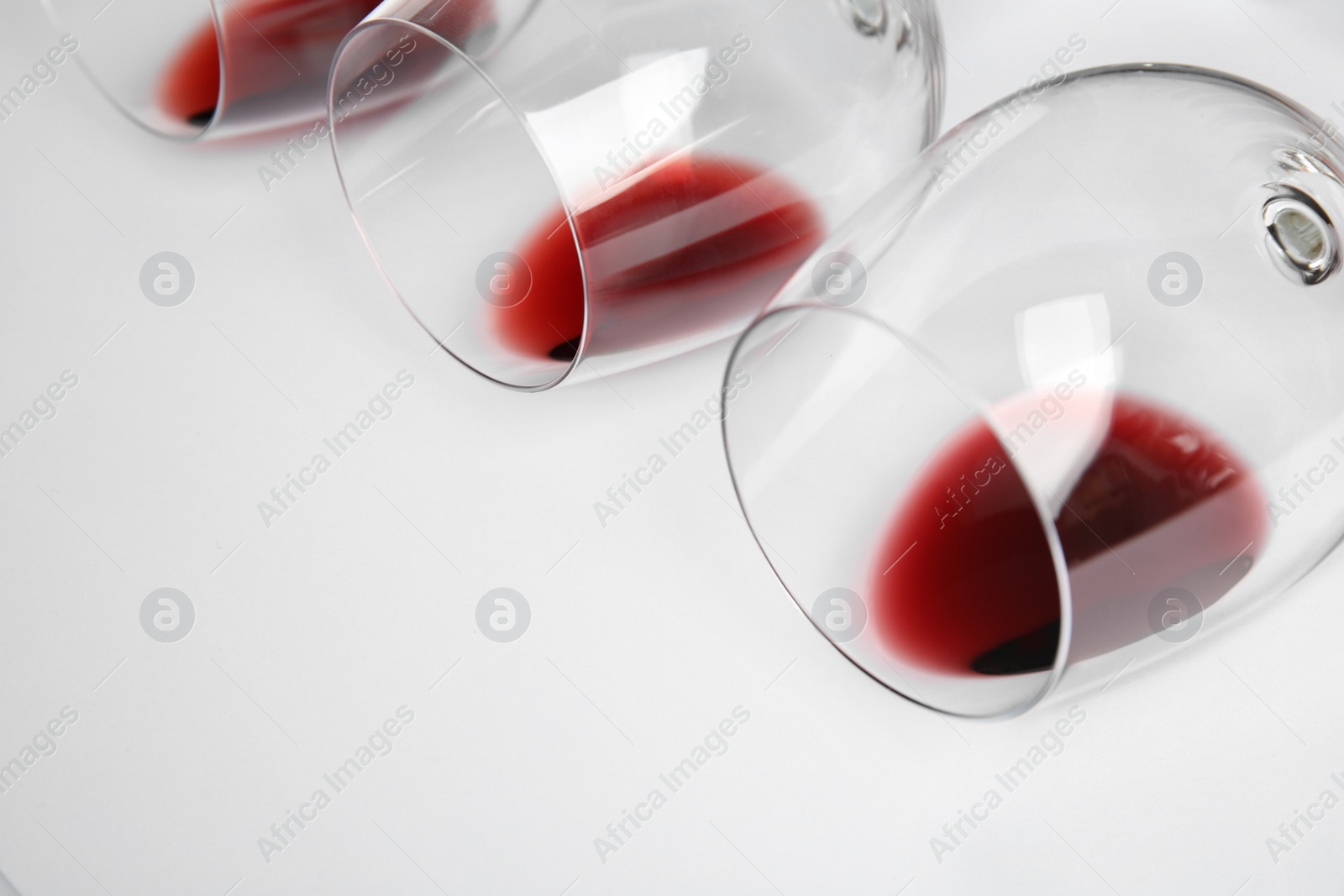 Photo of Transparent glasses with exquisite red wine on white background, closeup