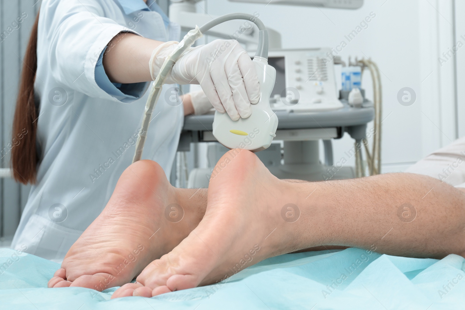 Photo of Doctor conducting ultrasound examination of patient's foot in clinic