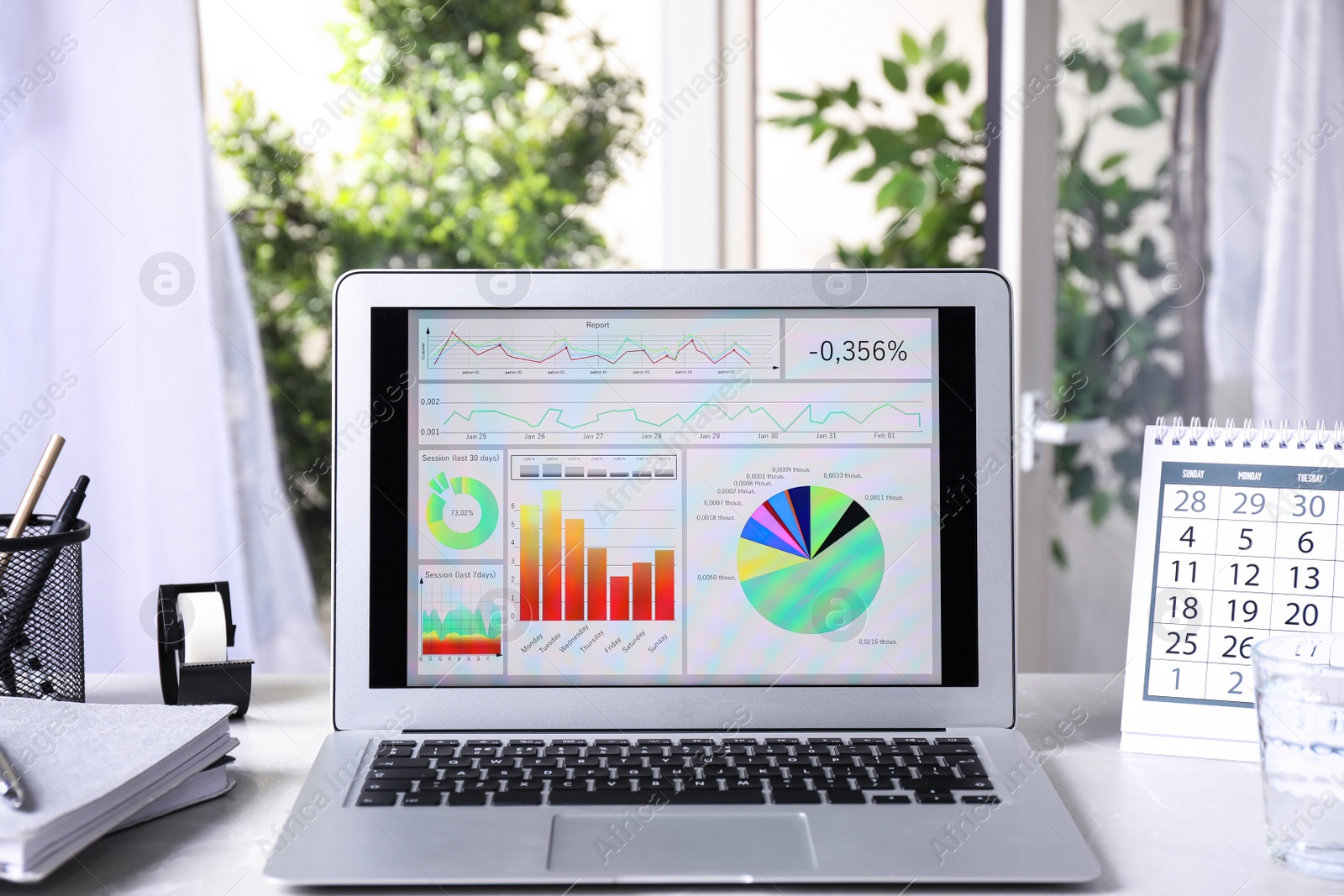 Photo of Modern laptop with diagrams on table in office