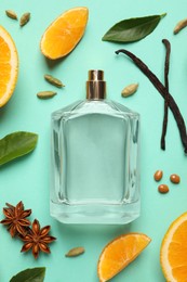 Flat lay composition with bottle of perfume and fresh citrus fruits on turquoise background