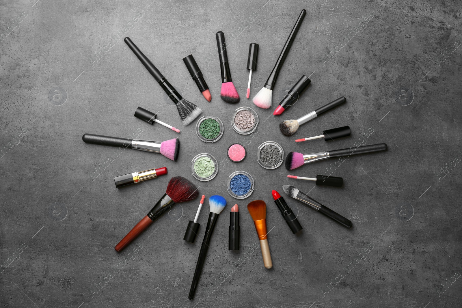 Photo of Flat lay composition with cosmetic products and makeup brushes on grey background