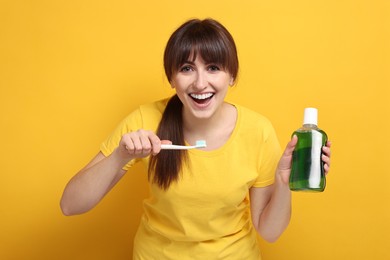 Photo of Young woman with mouthwash and toothbrush on yellow background