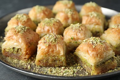 Photo of Delicious fresh baklava with chopped nuts on grey table, closeup. Eastern sweets
