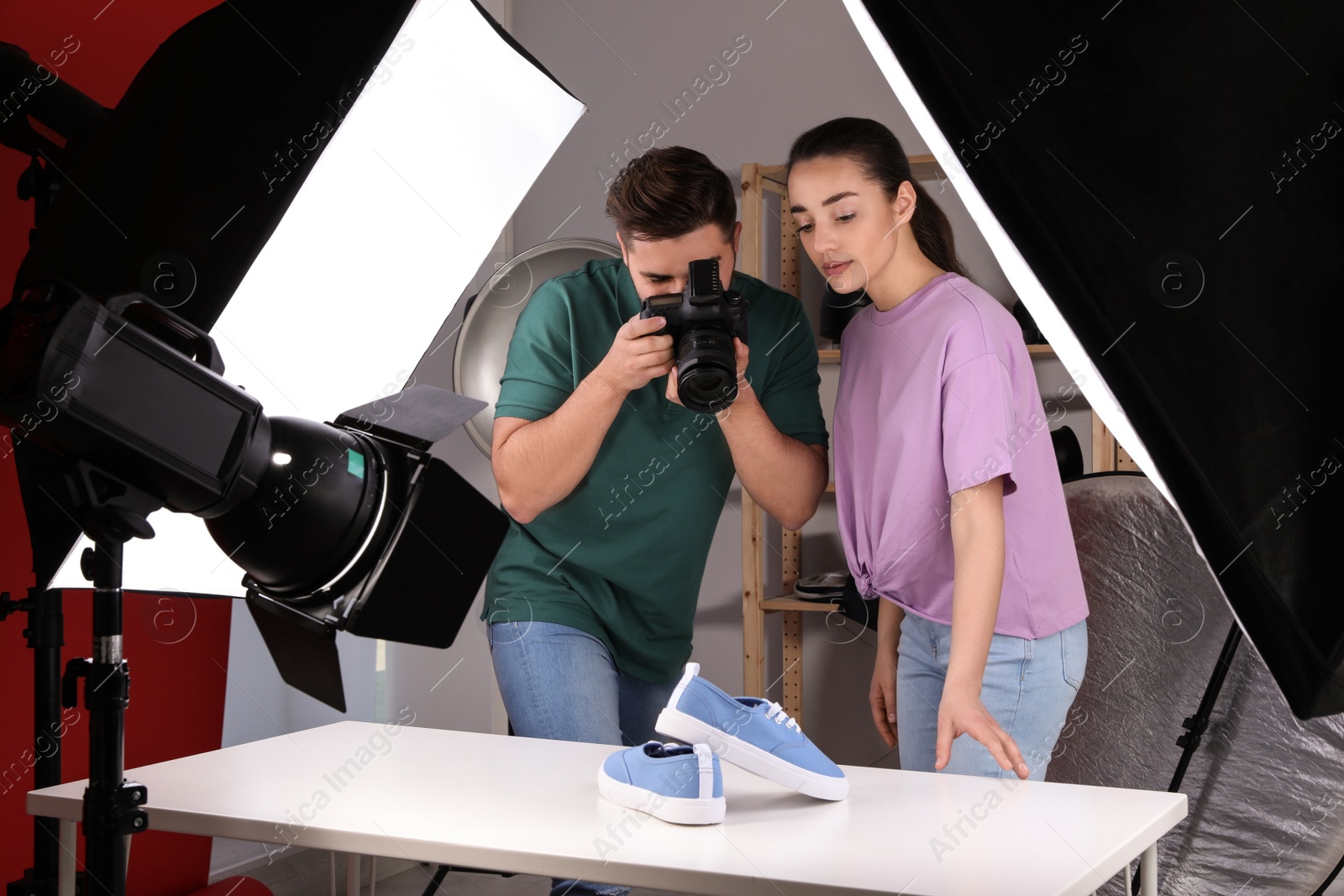 Photo of Professional photographers shooting stylish shoes in studio