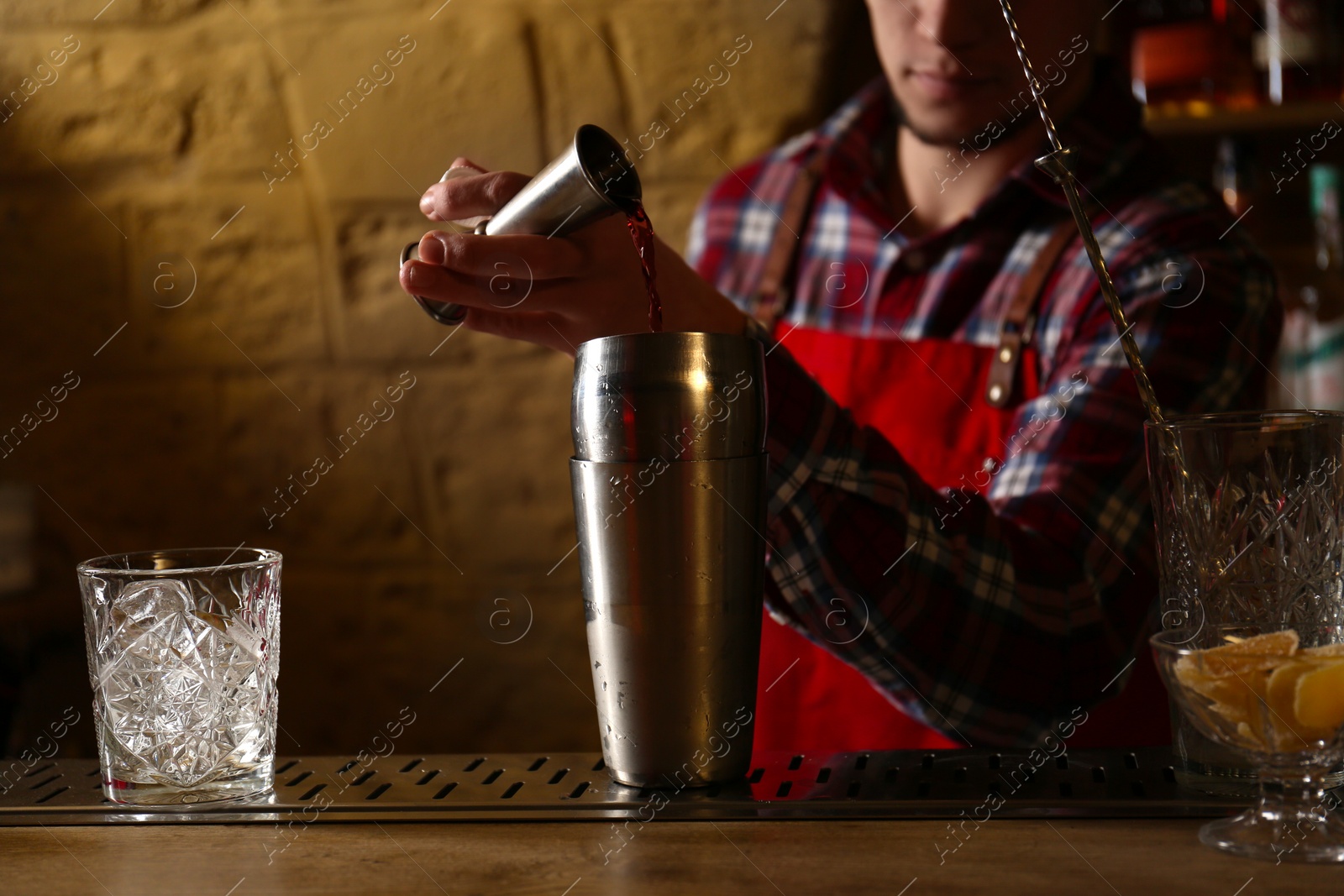 Photo of Bartender preparing fresh alcoholic cocktail at bar counter, closeup